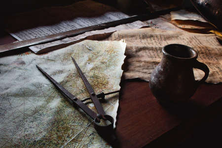 Old metal divider on a map on the captain's table aboard a pirate shipの写真素材
