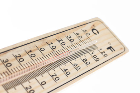 A wooden temperature thermometer isolated against a pure white background with red mercuryの写真素材