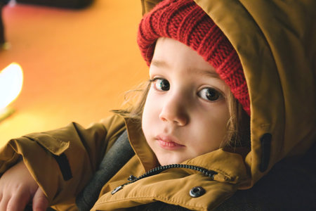 A young white Caucasian boy wearing thick winter clothes looking directly at the cameraの写真素材