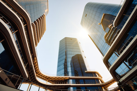Cityscape view from below looking directly up at tall high-rise modern business buildings with glass facadeの写真素材