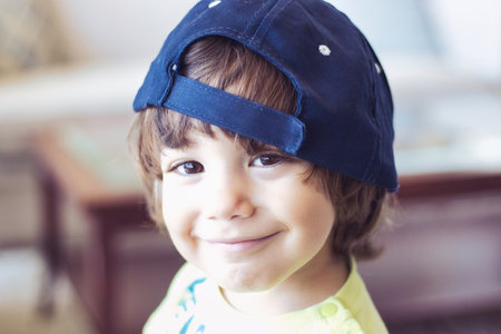 Headshot portrait of a cute happy white Caucasian boy wearing a baseball cap, smiling and looking directly at the cameraの写真素材