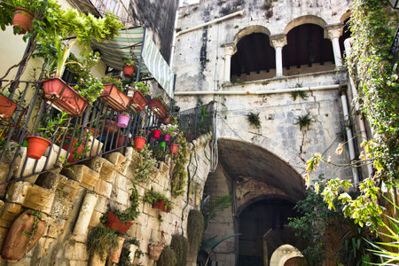 A typical old Italian courtyard with stone steps and balcony with archesの写真素材