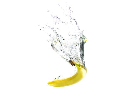 one banana falling into water on a white background with splashes.の写真素材