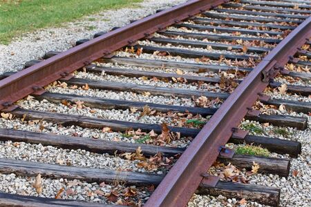 Photo of the rusty railroad and fallen leaves in autumn timeの写真素材