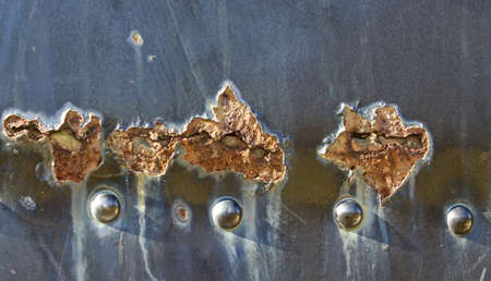 Photo of the old peeled black painting on the rusty metal wallの写真素材