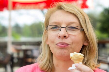 Caucasian woman eating icecream in the park