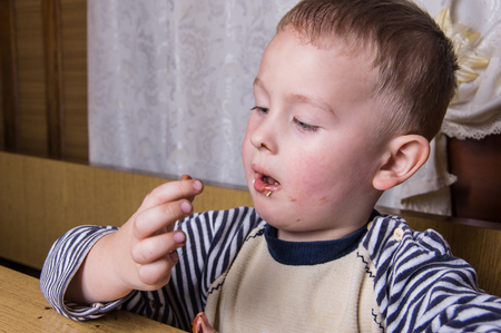 A young caucasian boy eat gingerbreadの写真素材