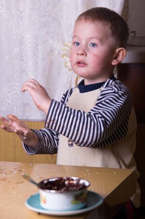 A young caucasian boy eat gingerbreadの写真素材