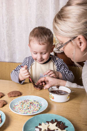 a young caucasian boy decoratingcookiesの写真素材