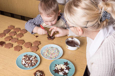a young caucasian boy decoratingcookiesの写真素材