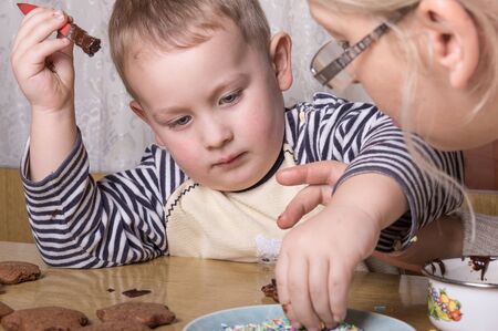 a young caucasian boy decoratingcookiesの写真素材