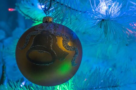 a golden xmass ball hanging at xmass treeの写真素材