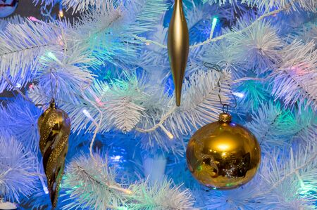 a golden xmass ball hanging at xmass treeの写真素材