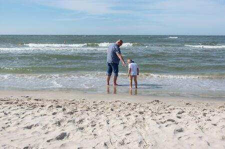 Caucasian father and his son playin at the beachの写真素材