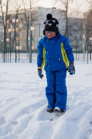 a small aucasian boy playing during wintertimeの写真素材