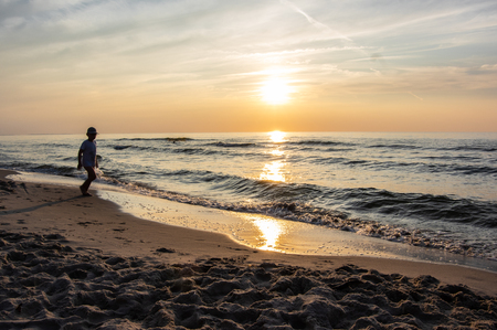 A shape of boy at the beach during sunsetの写真素材
