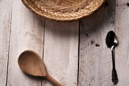 A white rustic wooden tabel with basket, wooden spoon and tea spoonの写真素材