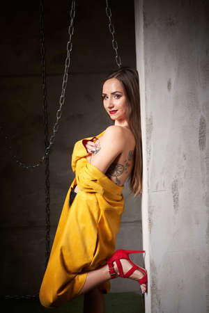 beautiful woman posing with yellow jacket and chainsの写真素材