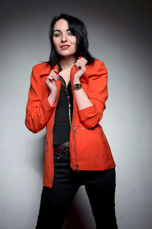 A young brunette wearing an orange suit,の写真素材