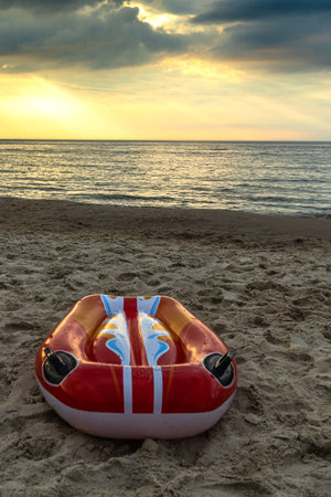 A beautiful sunset and a surfboard lying on the beach.の写真素材