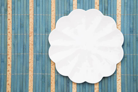 White porcelain plate on a straw backgroundの写真素材