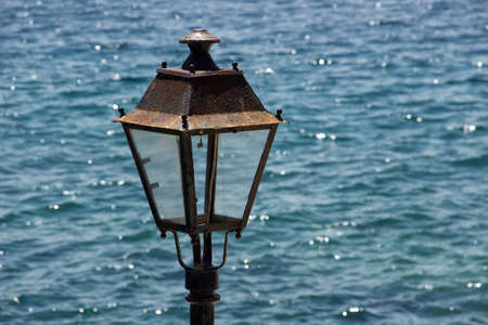 Old rusty metal lantern at the sea backgroundの写真素材