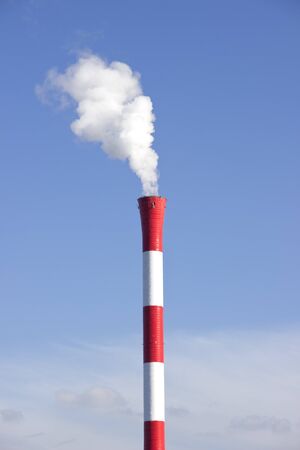 Industrial smoking chimney at the blue cloudy skyの写真素材