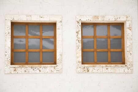 Two wooden windows on a marble facade