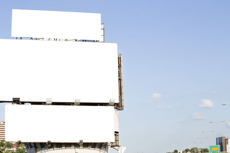Three blank billboards over a blue skyの写真素材