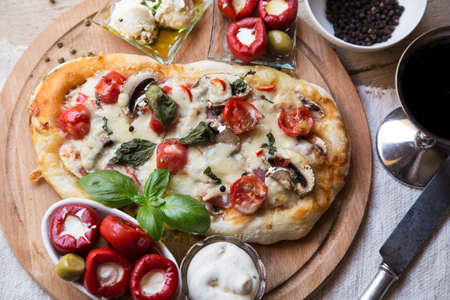 Rustic pizza with the marinated peppers and a glass of wineの写真素材