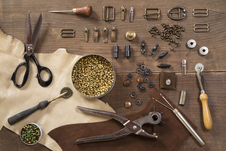 Leather craft tools on a wooden background