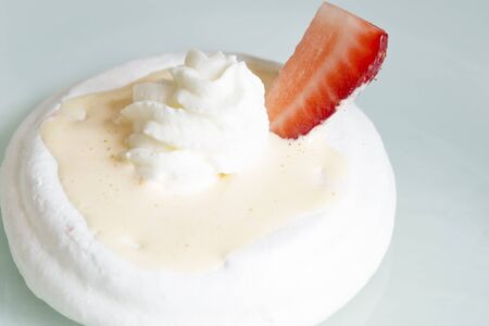 Meringue with strawberry on a plateの写真素材