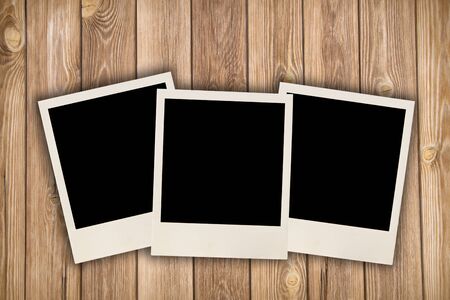 Three blank images on a wooden backgroundの写真素材