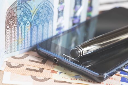 Mobile phone, pen and euro banknotes, vintage styleの写真素材