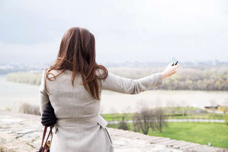 Girl taking pictures on mobile phoneの写真素材