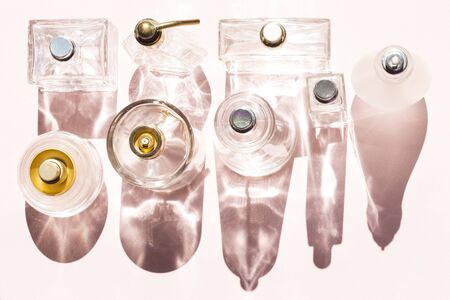 Perfume bottles on a bright light with shadowsの写真素材