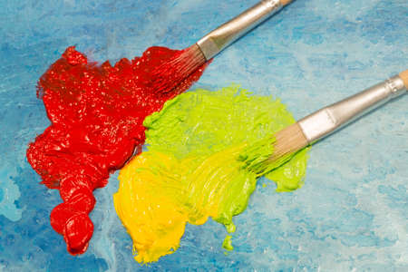 Red and green oil colors on blue backgroundの写真素材