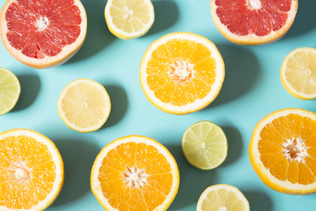 Orange and lemon halves on blue backgroundの写真素材