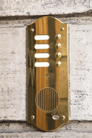 Brass intercom on marble facade