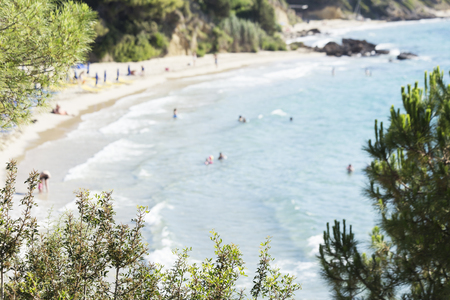 Beach with the turquoise sea and swimmers - blurred omageの写真素材