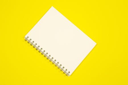 Note book on yellow backgroundの写真素材