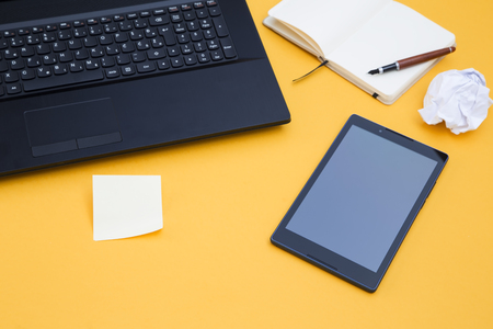 Tablet and laptop on yellow backgroundの写真素材