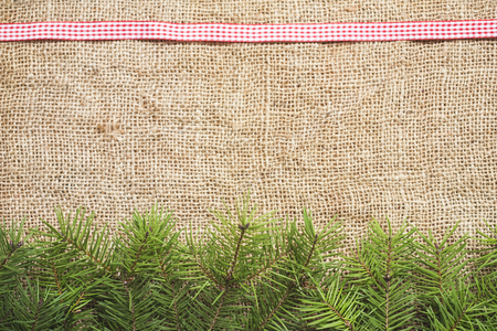 Christmas background with burlap and fir branchの写真素材
