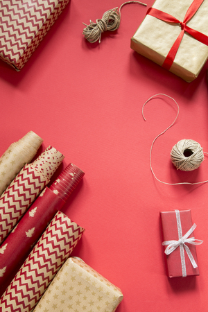 Wrapping Christmas presents on red paper backgroundの写真素材