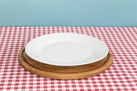 White plate and a cutting board on a tableの写真素材