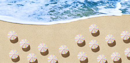Umbrellas on sand background from above