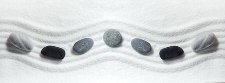 Zen rocks on white sand pattern