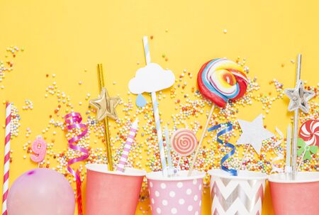 Birthday candies and accessory on yellow backgroundの写真素材