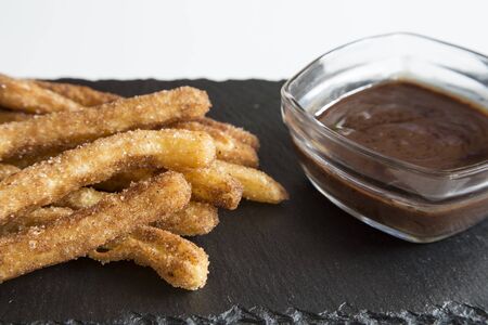 Churro stick with chocolate on black granite boardの写真素材
