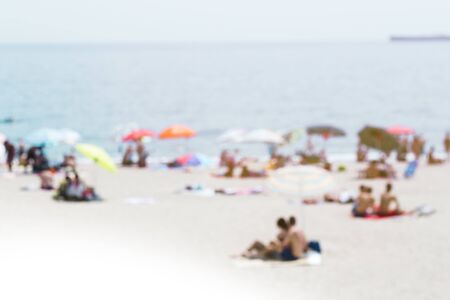 Beach by the sea with sunbathersの写真素材